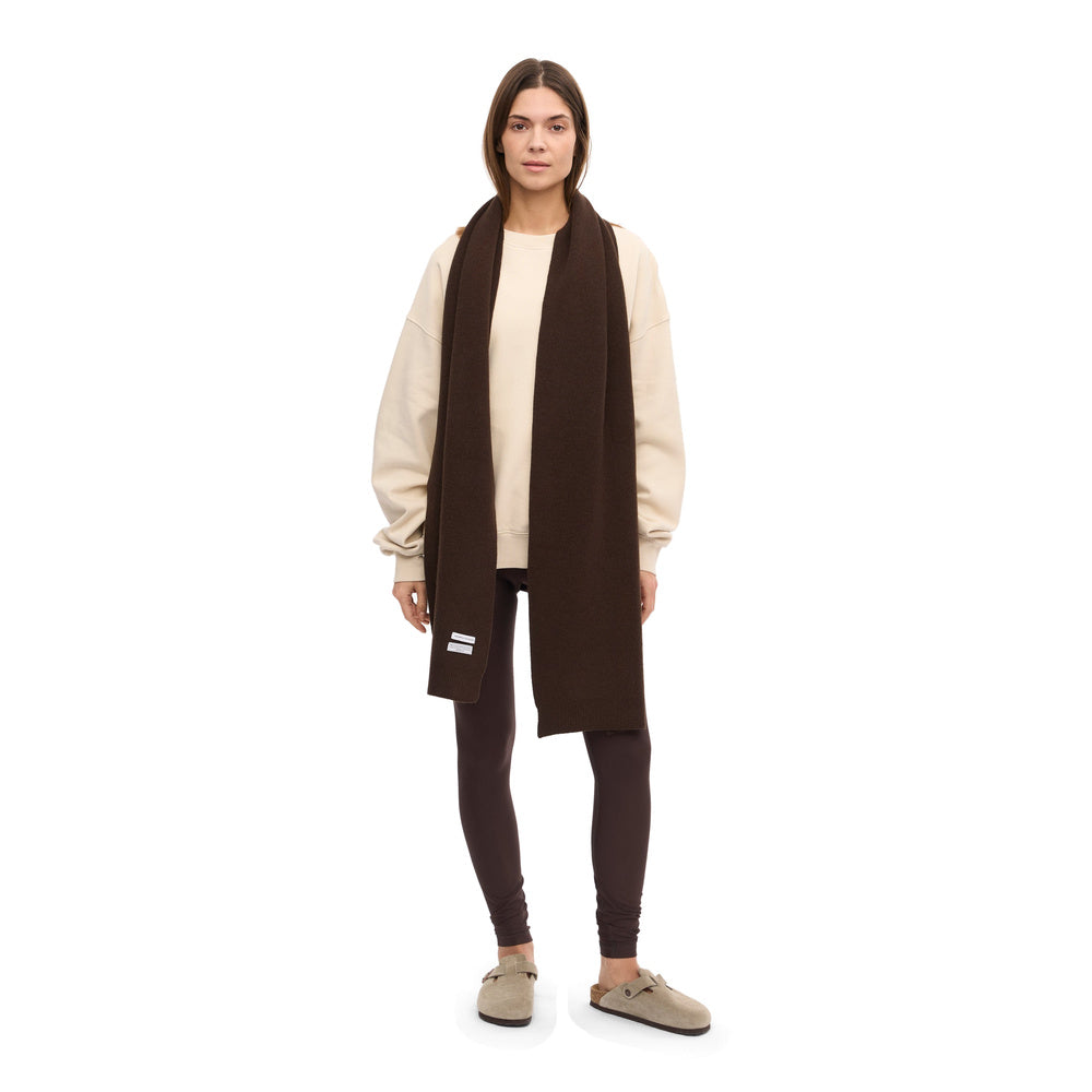 Sciarpa Colorful Standard Merino Wool Scarf Coffee Brown – indossata da una modella, figura intera