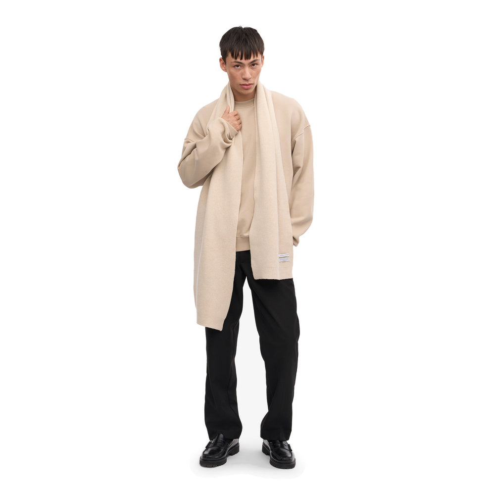 Sciarpa Colorful Standard Merino Wool Scarf Ivory White – indossata da un modello, figura intera
