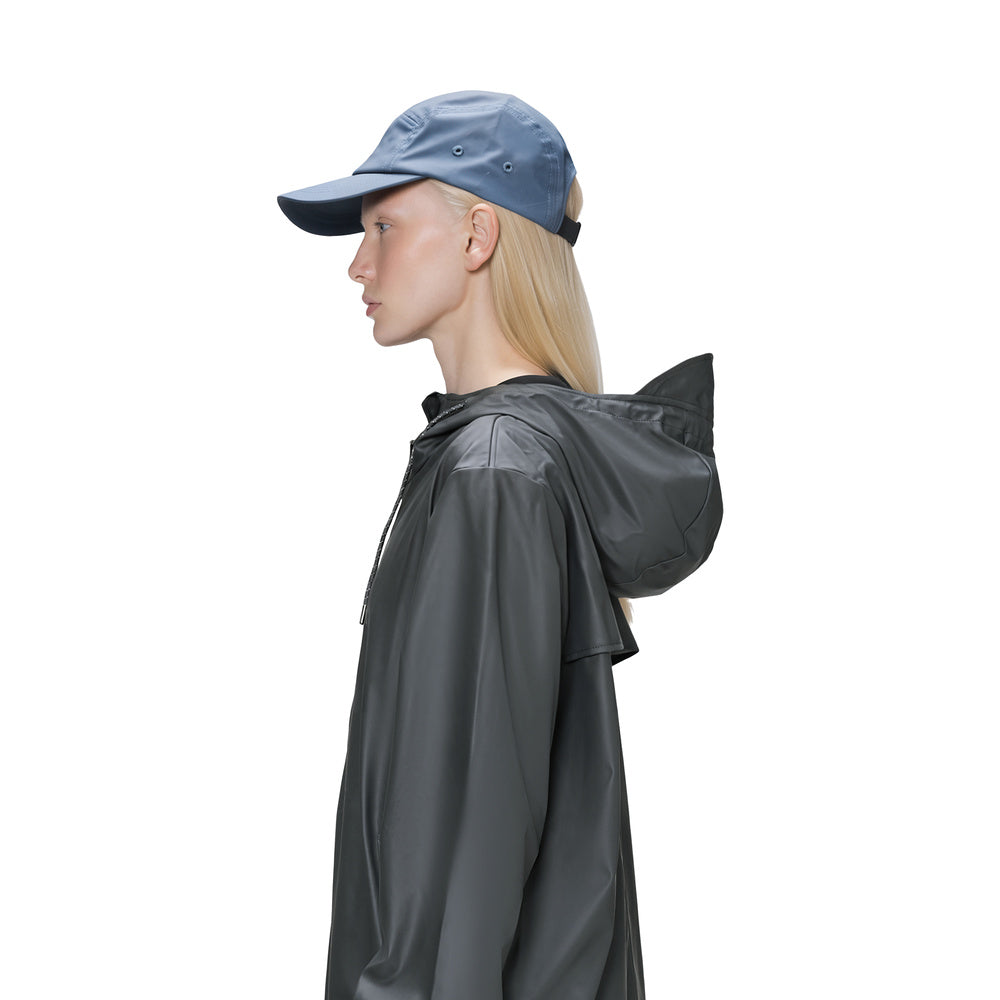 Cappellino Rains 5 Panel Cap Blue Dusk – indossato da una modella