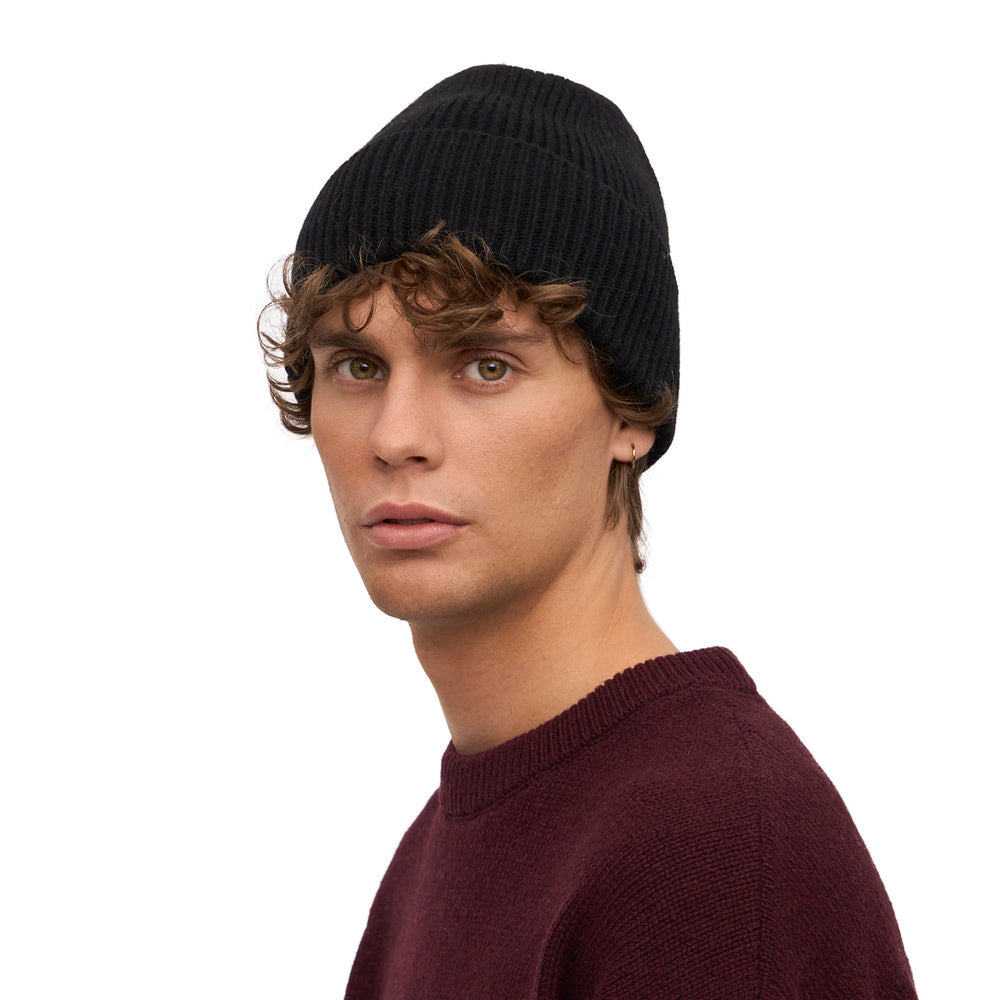 Colorful Standard Merino Wool Beanie Deep Black – worn by a male model, three-quarter view