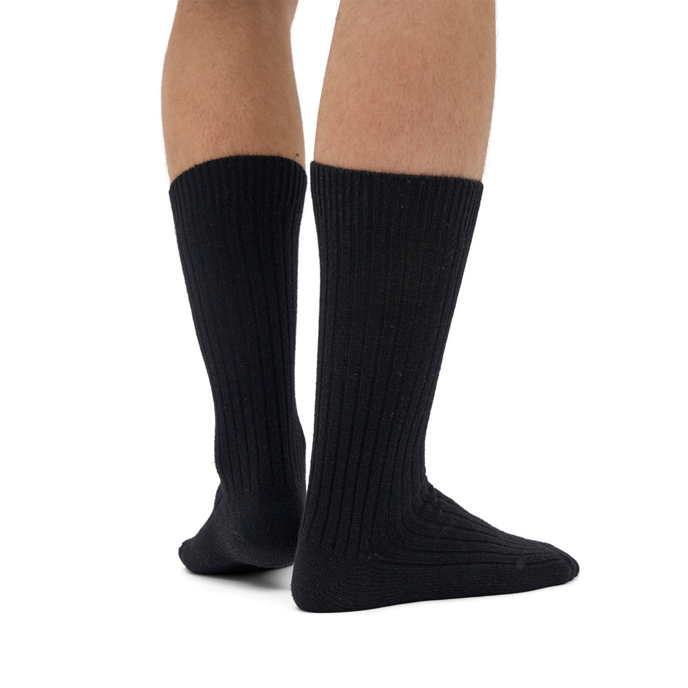 Calze Colorful Standard Merino Wool Blend Sock Deep Black – indossate da un modello, vista di tre quarti