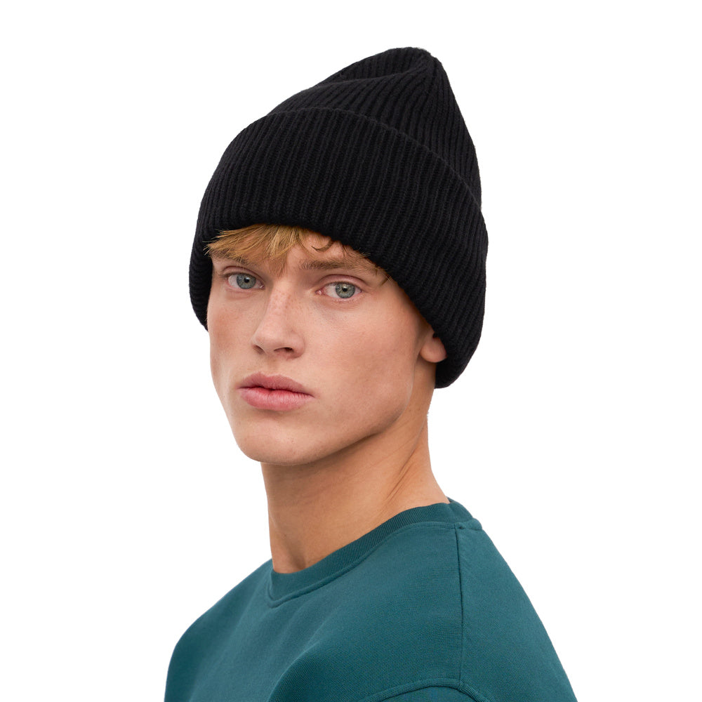 Berretto Colorful Standard Merino Wool Hat Deep Black – indossato da un modello, vista di tre quarti