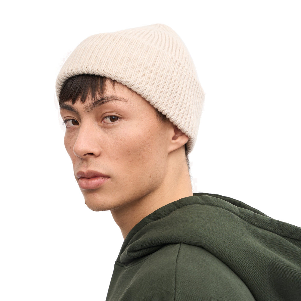 Berretto Colorful Standard Merino Wool Hat Ivory White – indossato da un modello, vista di tre quarti