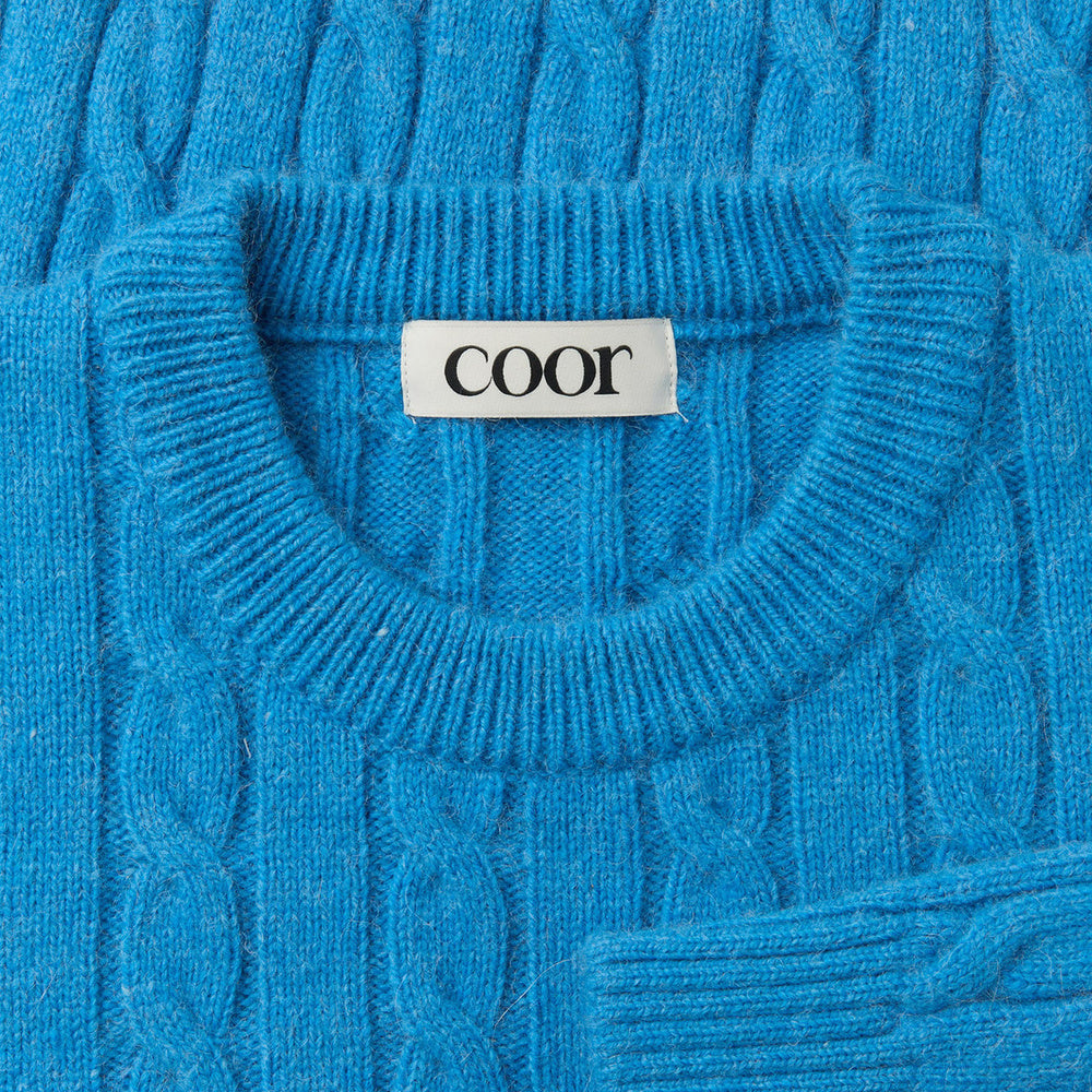 Maglione COOR Alpaca Blend Cable Sweater Blue Opal – dettaglio del girocollo con etichetta COOR