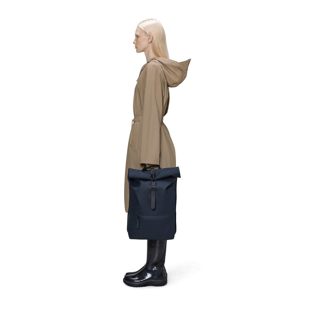 Zaino Rains Rolltop Rucksack Navy – portato a mano da una modella