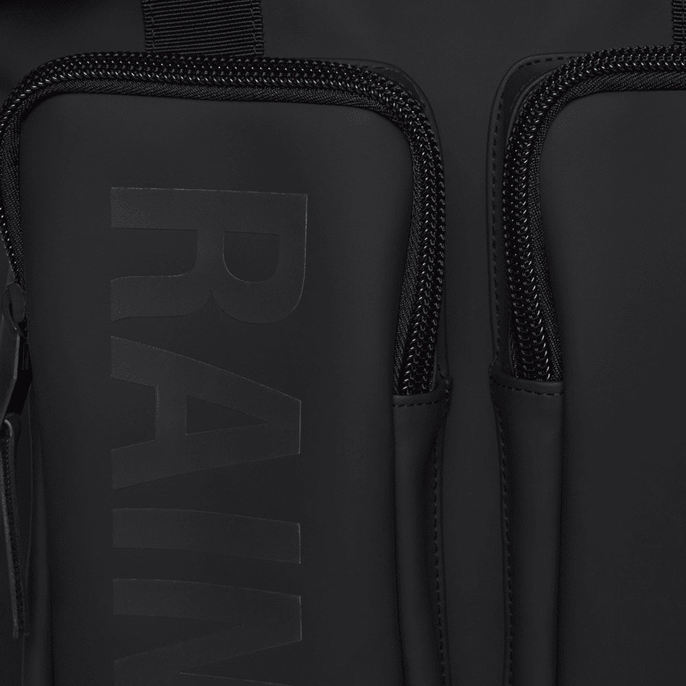 Zaino Rains Texel Tote Backpack Black – dettaglio delle tasche frontali con logo