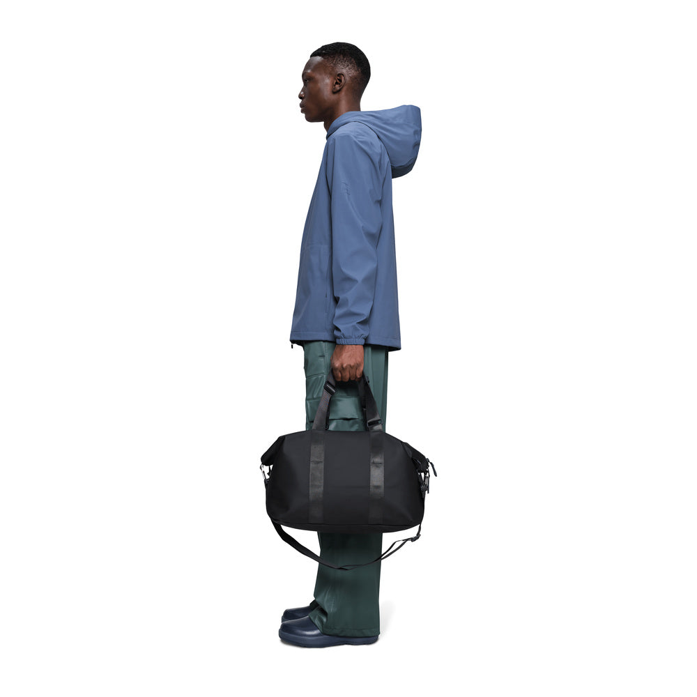 Borsa da viaggio Rains Valera Weekend Bag Small Black – portata da un modello