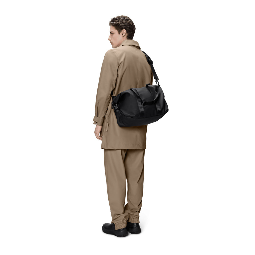Borsa da viaggio Rains Valera Weekend Bag Small Black – portata a spalla da un modello